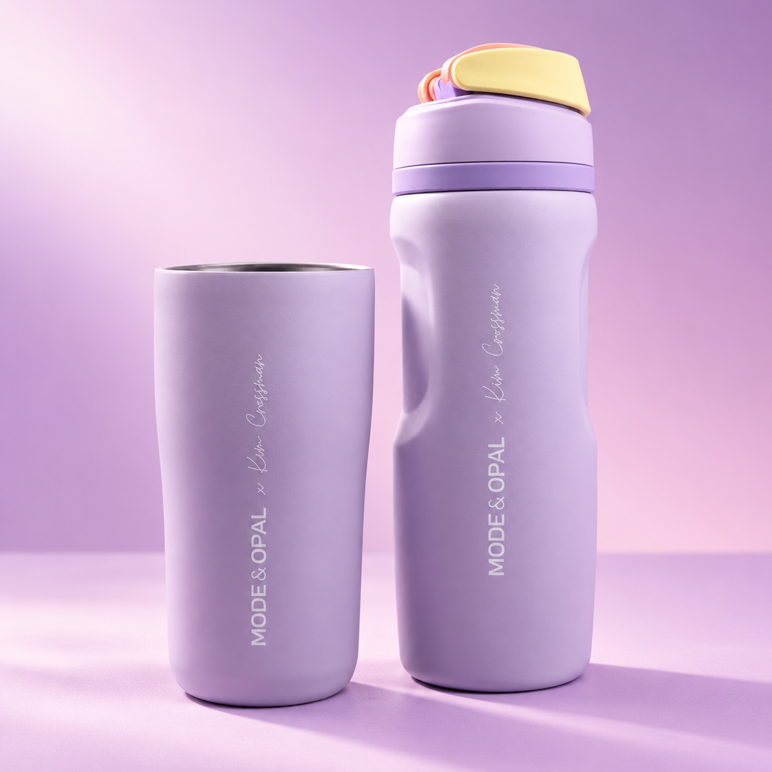 A matching insulated travel tumbler and water bottle set in a soft lavender-purple color, featuring the vertical white text 'MODE & OPAL x Klein CGFashion' on both items, set against a matching purple gradient background.